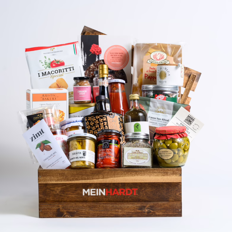 wooden crate with dark stain with Meinhardt written on it, containing about 27 food snacks, treats and 2 drinks.