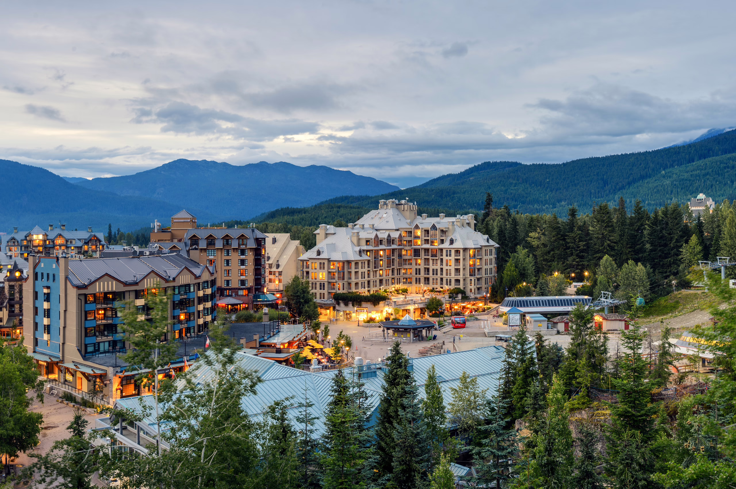 Whistler, British Columbia, Canada aerial hotels, lights, trees, mountains, cloudy weather, evening time