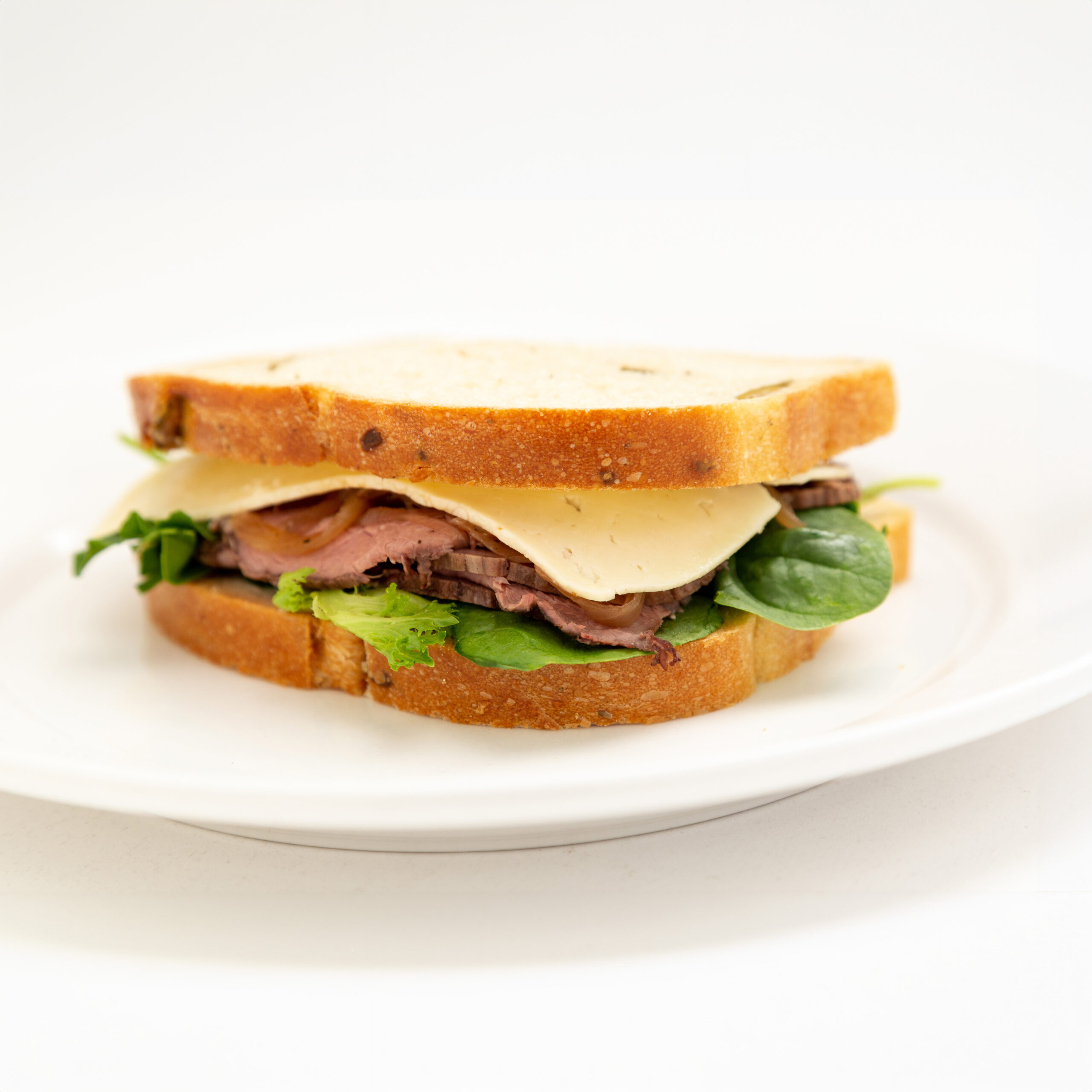 Meinhardt-ROASTED-BEEF-Sandwich Walnut loaf, horseradish mayonnaise, roast beef, Havarti cheese, caramelized onion, and mixed spring green.