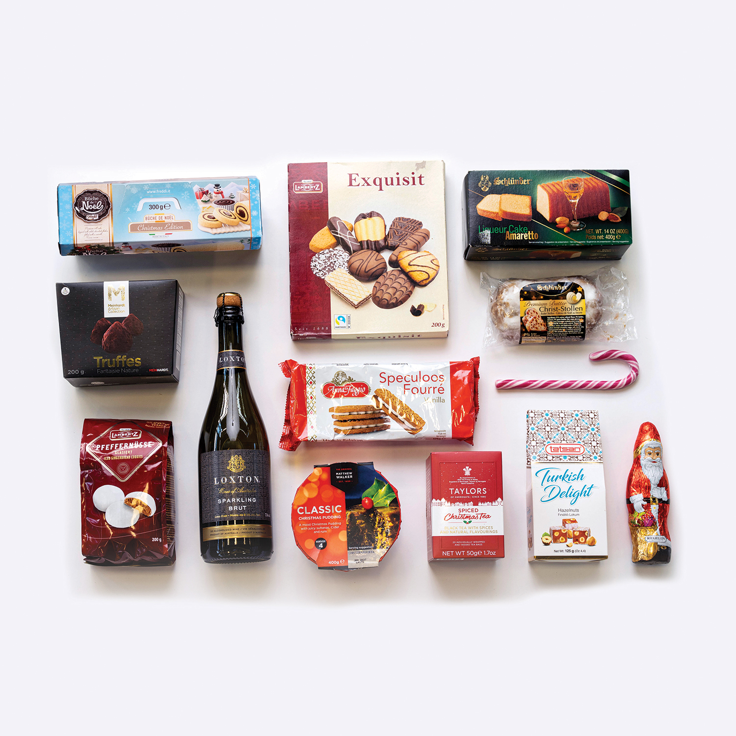 Spirits of the Season Holiday Gift Basket contents Spirits of the Season holiday gift basket with festive treats and seasonal flavors laid out on white background